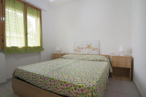 Schlafzimmer mit einem Bett und einem Fenster in der Unterkunft Appartamento Prato in Follonica