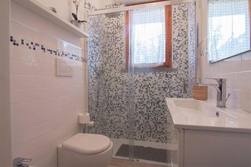 ein Bad mit einem WC, einem Waschbecken und einer Dusche in der Unterkunft Appartamento Prato in Follonica