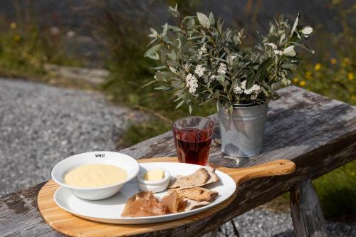 a plate of food on a wooden table with a drink at Rauland Feriesenter in Rauland