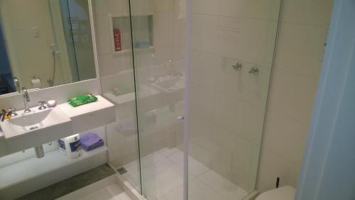 a bathroom with a shower and a sink and a toilet at Guest House Marly in Rio de Janeiro