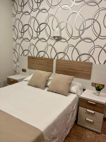 a bedroom with a bed and a wall with swirls at PENSION NAVAS in El Cabo de Gata