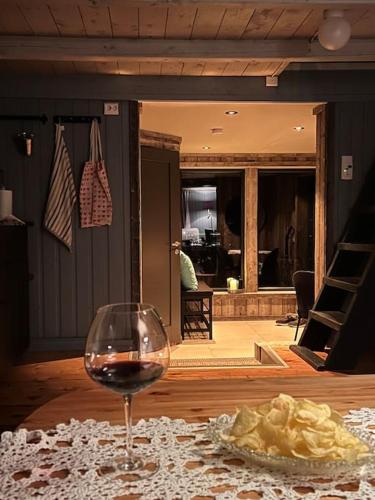a glass of wine sitting on top of a table at Stabbur med fantastisk utsikt! in Steinkjer