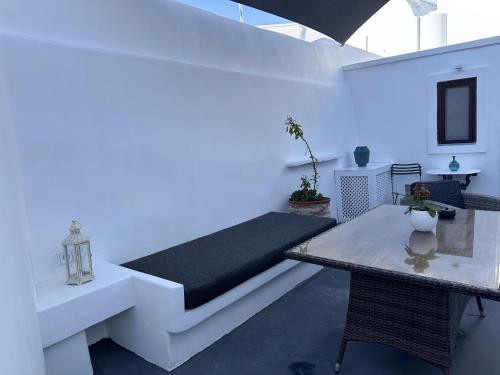 a white room with a bed and a table at Argy's Luxury Caves in Megalokhori