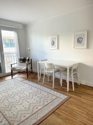 une salle à manger blanche avec une table et des chaises blanches dans l'établissement Appartement rénové CANNES, palm beach, à Cannes