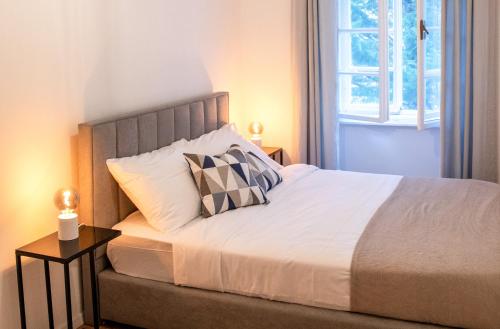 łóżko z dwoma poduszkami w sypialni w obiekcie Cosy Castle Flat in Ljubljana Center - FREE PARKING w Lublanie