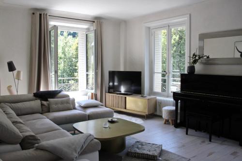 a living room with a couch and a piano at Appartement Parc in Saint-Gervais-les-Bains