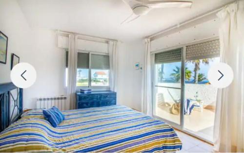 a bedroom with a bed and a large window at Chalet La Sopera La Manga in La Manga del Mar Menor