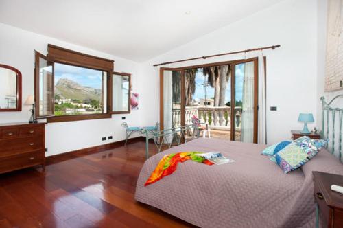a bedroom with a bed with a dresser and a window at Can Brenno in Port de Pollensa