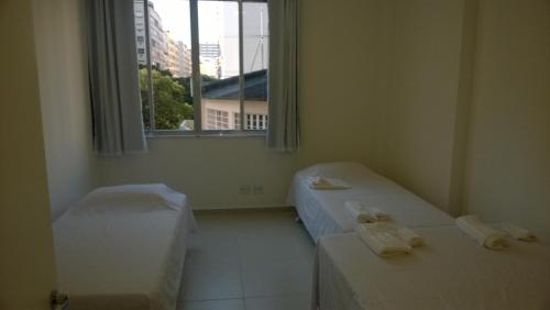 Habitación con 2 camas y ventana en Guest House Marly, en Río de Janeiro