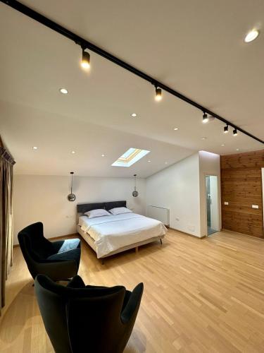 a bedroom with a bed and chairs in a room at Bianca Hotel & Villa in Tirana