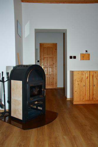 a fireplace in a living room with a wooden floor at Horská vila Heda in Vrbno pod Pradědem