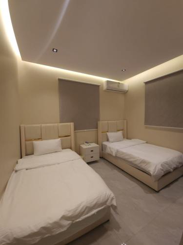 Habitación con 2 camas y pizarra en رهف ريزيدنس Rahaf smart residence, en Riad