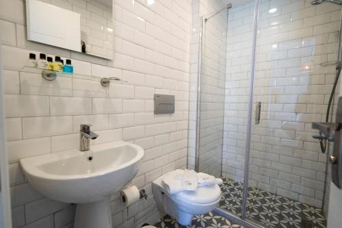 uma casa de banho branca com um lavatório e um WC em LONDİA OTEL em Alacati