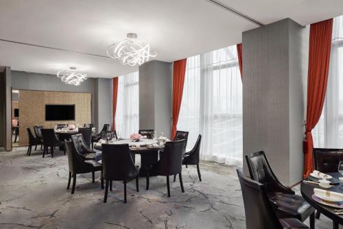 a dining room with tables and chairs and windows at JW Marriott Hotel Shenzhen in Shenzhen