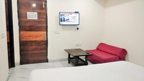 Habitación con sofá rojo y puerta en offf en Nueva Delhi