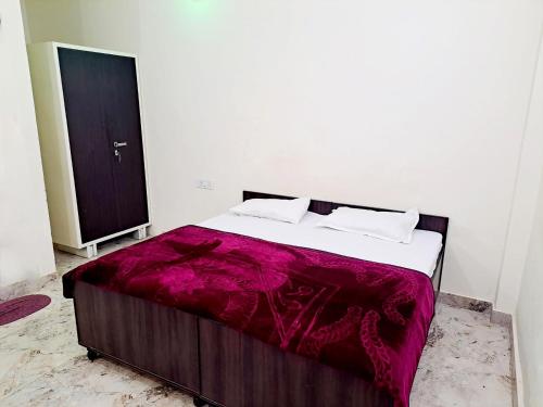 新德里的住宿－offf，白色客房的一张床位,配有紫色毯子