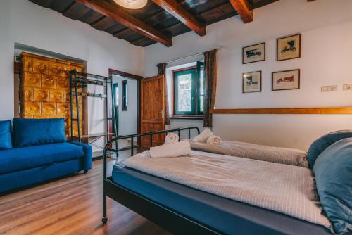een slaapkamer met een bed en een bank bij Feher Barany Apartment in Szigliget