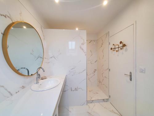 een badkamer met een wastafel en een spiegel bij Gîte de charme XIXe in Grand-Champ