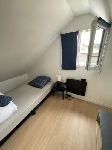 Cette petite chambre comprend un lit et une télévision. dans l'établissement maison de ville en centre ville cany-barville, à Cany-Barville