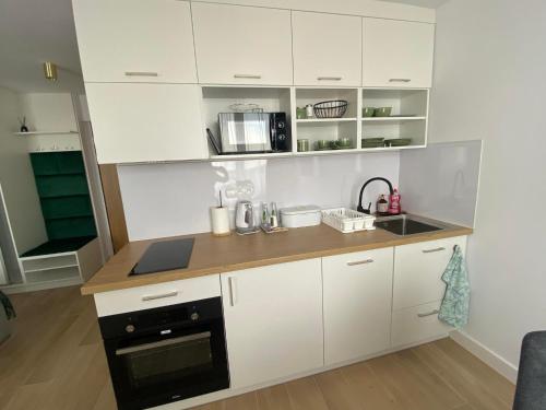 a kitchen with white cabinets and a black oven at Metalowiec in Stalowa Wola