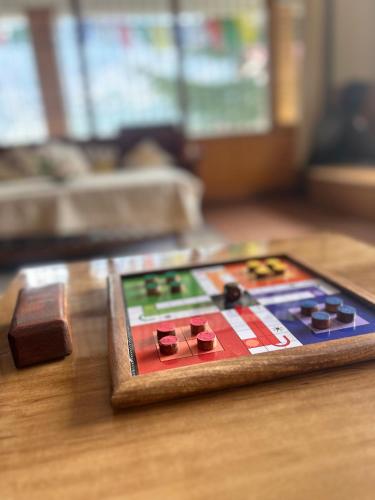 a wooden table with a game board on it at Urban Monk Stays and Cafe in Manāli
