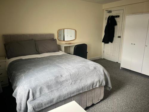 a bedroom with a bed and a mirror and a door at Studio Flat 7 With Private Shower & WC in Nottingham
