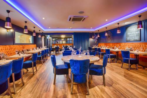 a dining room with tables and blue chairs at The Glenside in Drogheda