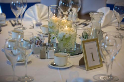 a table with candles and glass vases on it at The Glenside in Drogheda