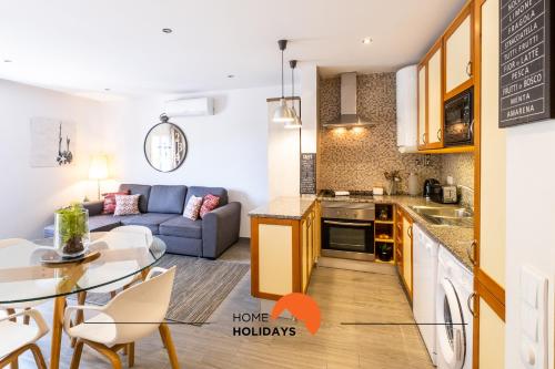 una cucina e un soggiorno con un divano e un tavolo di #094 Maresia Flats by Home Holidays ad Albufeira