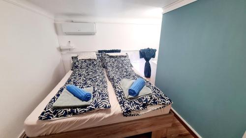 Una cama en una habitación con almohadas azules. en Big Base Apartment en Budapest