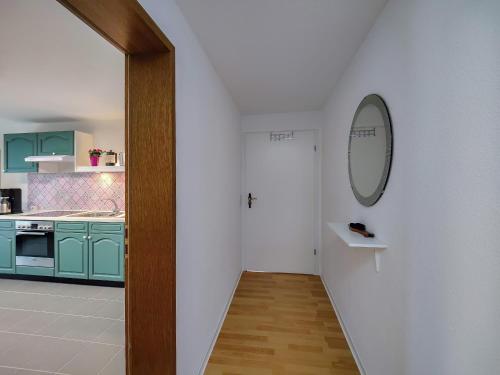 a hallway leading to a kitchen with a mirror on the wall at Fuchs und Hase in Illingen