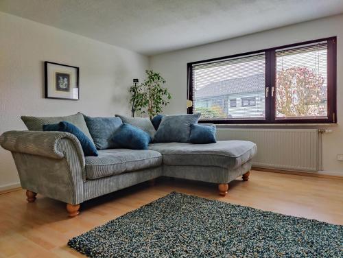 a living room with a couch with blue pillows at Fuchs und Hase in Illingen