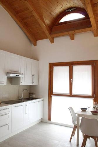 a kitchen with white cabinets and a table and a window at Charming & Modern in the city in Bergamo