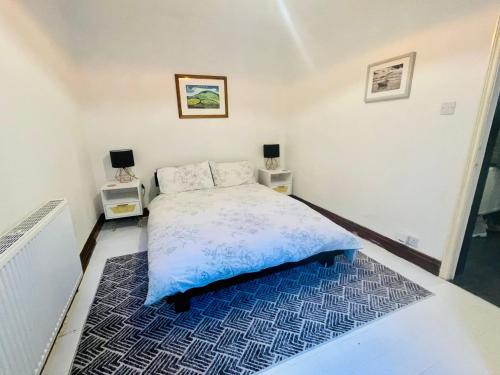 a bedroom with a bed and two night stands at Lovely Seaside Ground Floor Cottage Old Leigh in Leigh-on-Sea