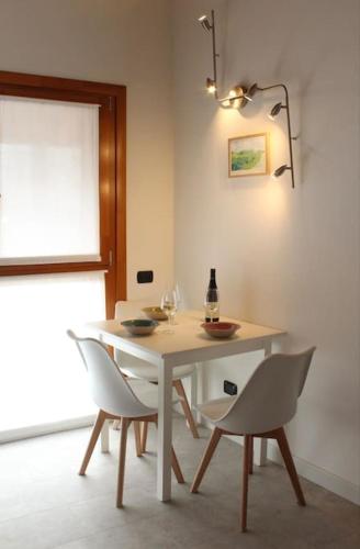 a white dining room table with chairs and a bottle of wine at Charming & Modern in the city in Bergamo