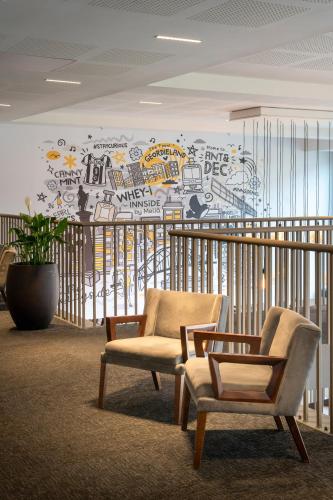 a room with two chairs and a wall with graffiti at INNSiDE by Meliá Newcastle in Newcastle upon Tyne