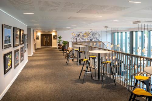a corridor with chairs and tables in a building at INNSiDE by Meliá Newcastle in Newcastle upon Tyne