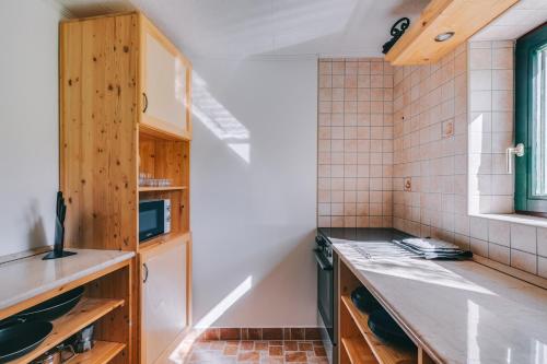 een keuken met houten kasten en een aanrecht bij Feher Barany Apartment in Szigliget