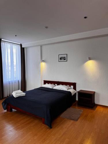 a bedroom with a bed with a blue comforter at Готель Elisavetgrad in Kropyvnytskyi