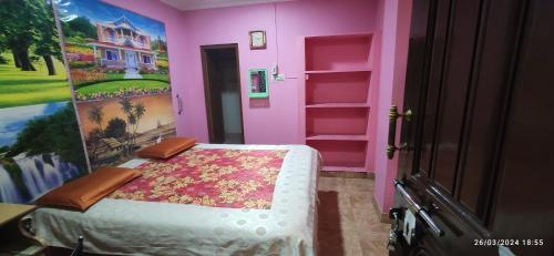 a bedroom with a bed in a pink room at Sri bagavan lodge in Tiruvannāmalai