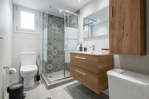 a bathroom with a toilet and a glass shower at Lemon Tree House Varkiza in Vari