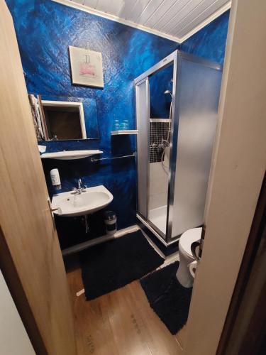 a blue bathroom with a sink and a toilet at Gasthof zur Post in Taxenbach