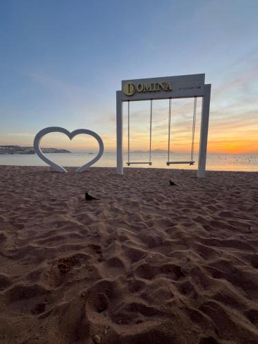 a sign on the beach with a heart drawn in the sand at Domina coral bay resort direct beach and lake 1 in Sharm El Sheikh
