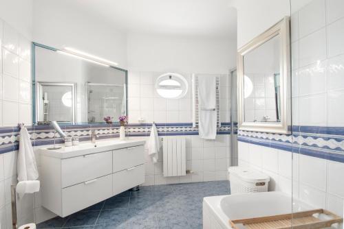 a white bathroom with a sink and a toilet at Casa Rosella in Carvoeiro