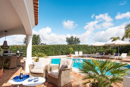 a patio with chairs and a swimming pool at Casa Rosella in Carvoeiro
