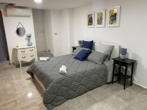 a bedroom with a large bed with blue pillows at Mavi house in Catania