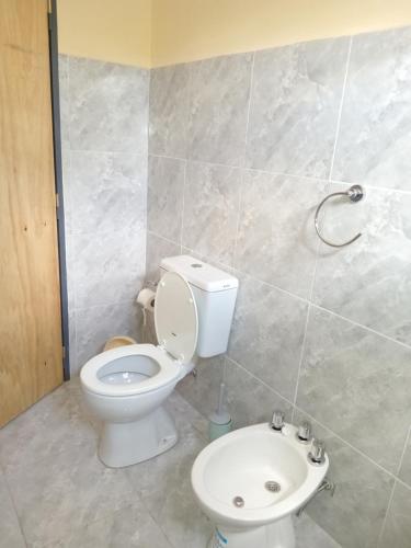 La salle de bains est pourvue d'une douche et de toilettes blanches. dans l'établissement Del sur ., à Médanos