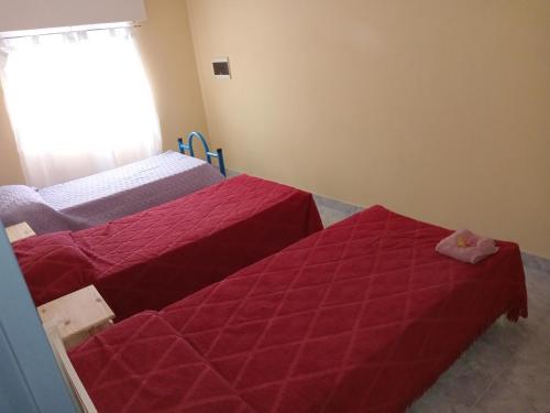 - 2 lits dans une chambre avec des draps rouges dans l'établissement Del sur ., à Médanos