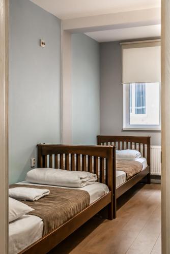 two wooden beds in a room with a window at Gar'is Hostel Lviv in Lviv
