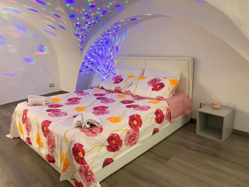 a bedroom with a bed with a floral comforter at Mavi house in Catania